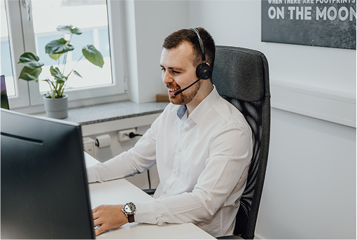 Healthcare professional speaking with a headset at a desk, representing admissions support.